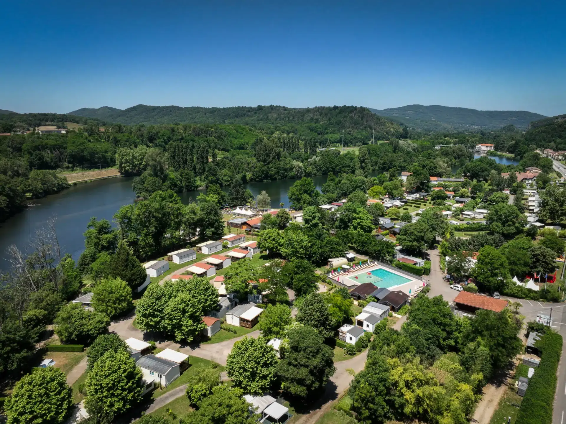 Les randonneurs profitent de la fraîcheur des sous-bois tandis que les enfants découvrent la nature en camping à Foix
